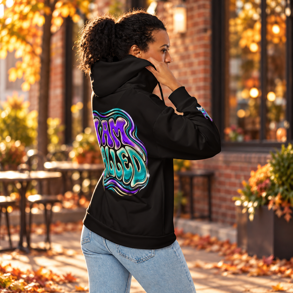 Fall lifestyle mockup showing the Royal Frequency black zip hoodie and purple teal I AM CALLED back design.